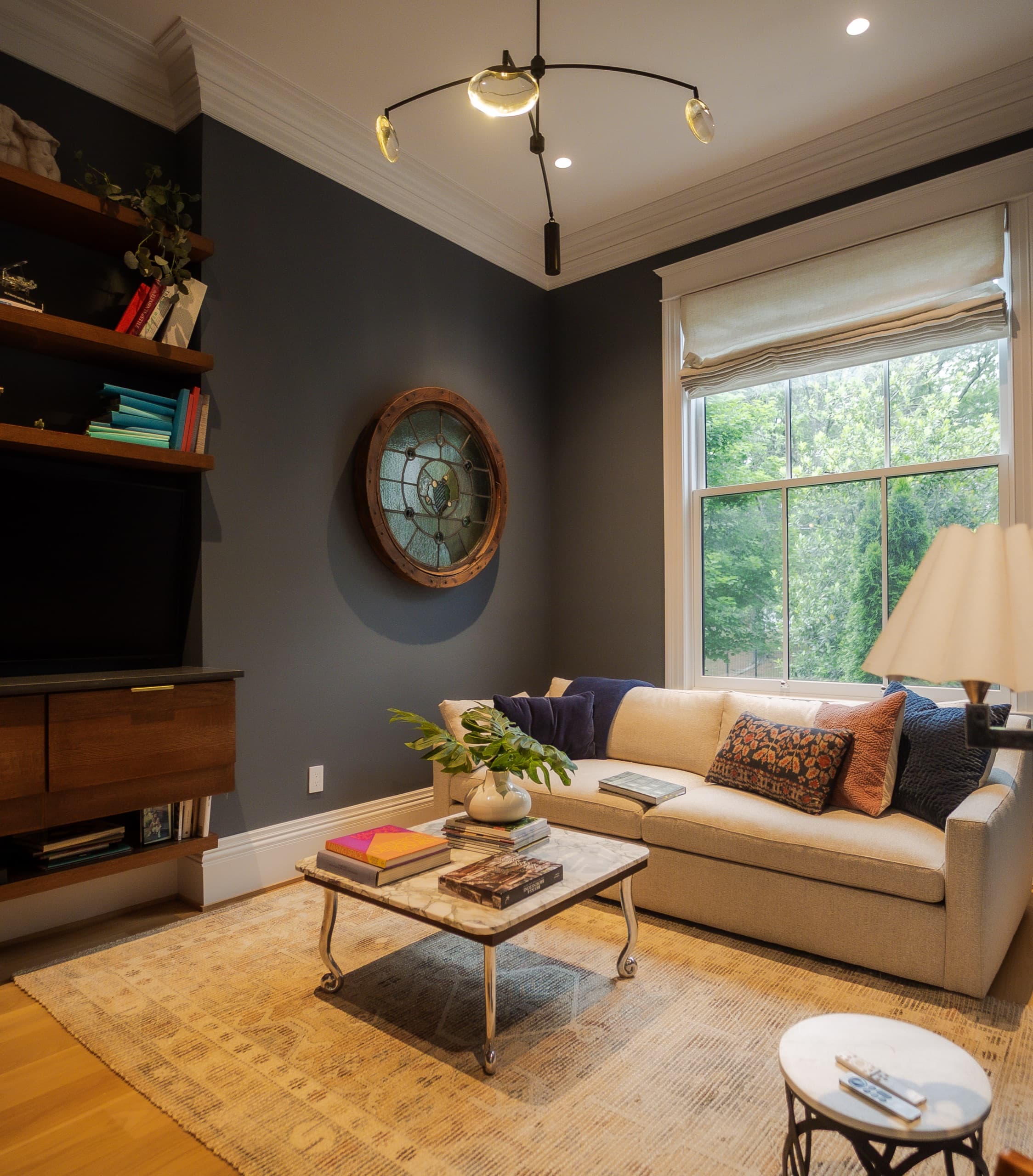 Den with deep navy walls, built-in shelving and a faded patterned rug