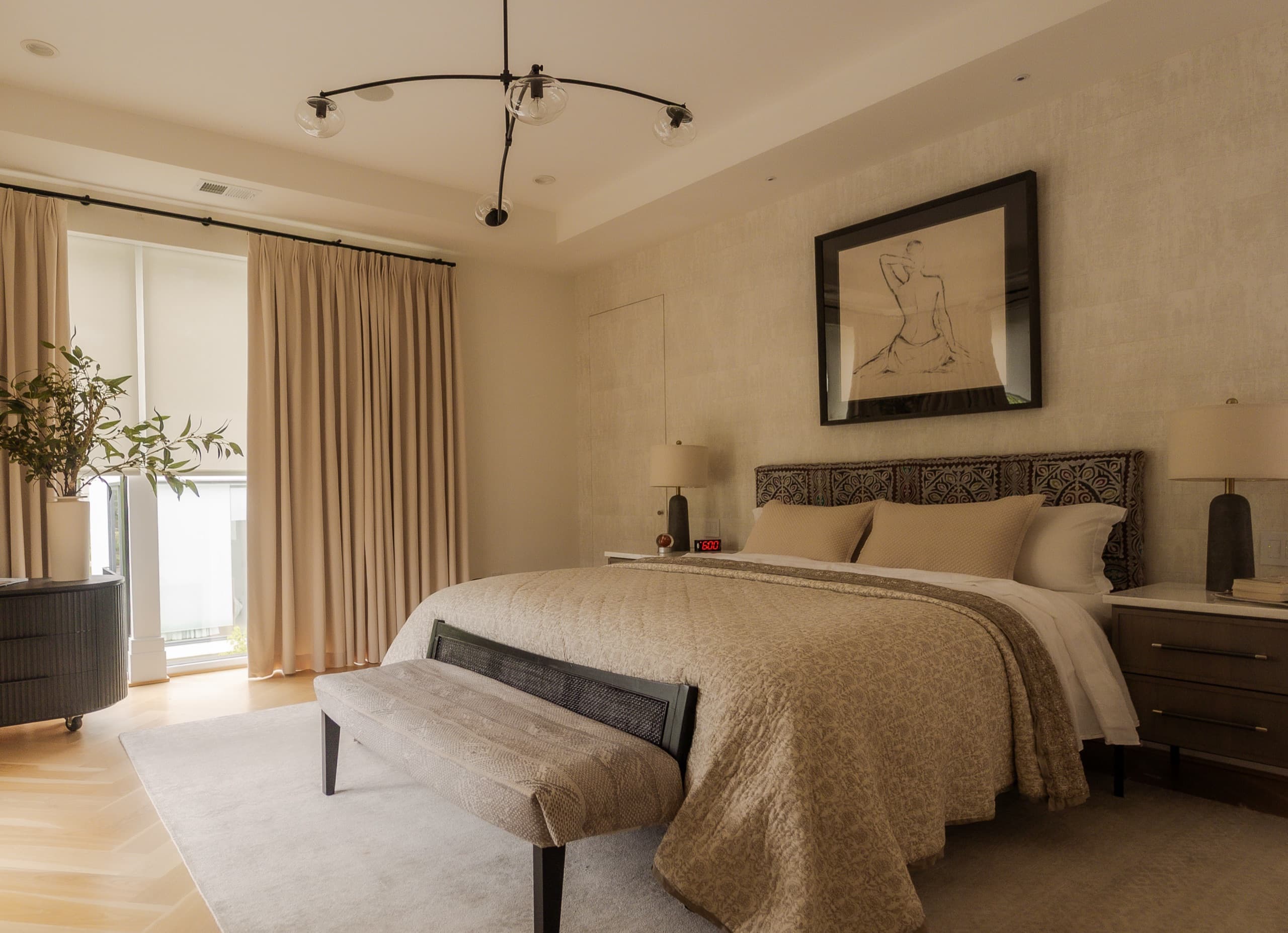 Principal bedroom with textured plaster walls, a branched ceiling light and an upholstered bench